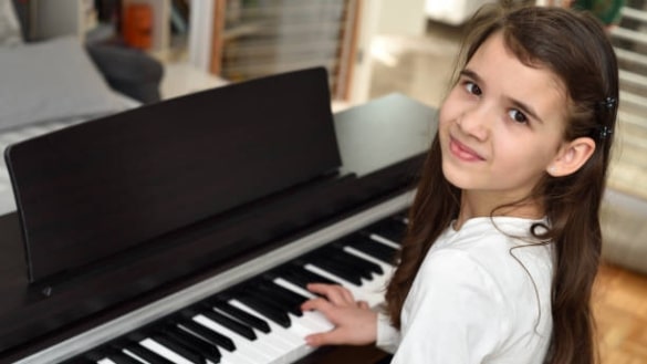 Marbella Music. Childrens Piano lessons. Student looking up while playing the piano.